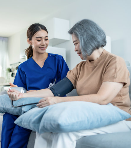 female caregiver evaluating blood pressure of elderly woman