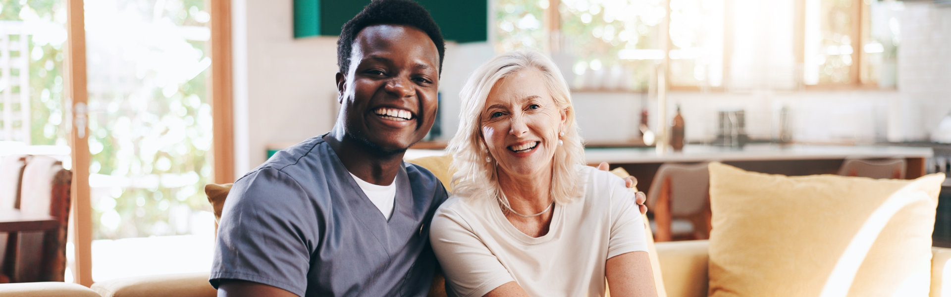 male caregiver and elderly woman smiling