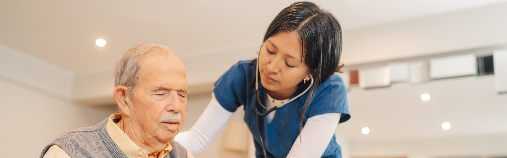 Home nurse checking the heartbeats of an elderly man