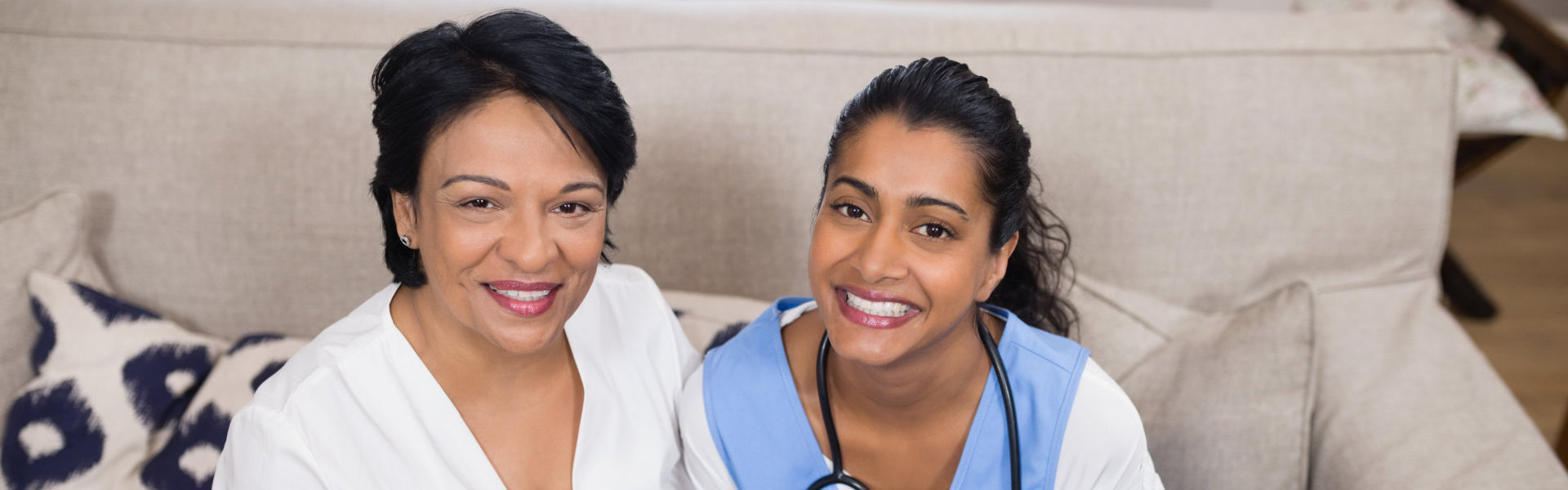 female caregiver and elderly woman smiling
