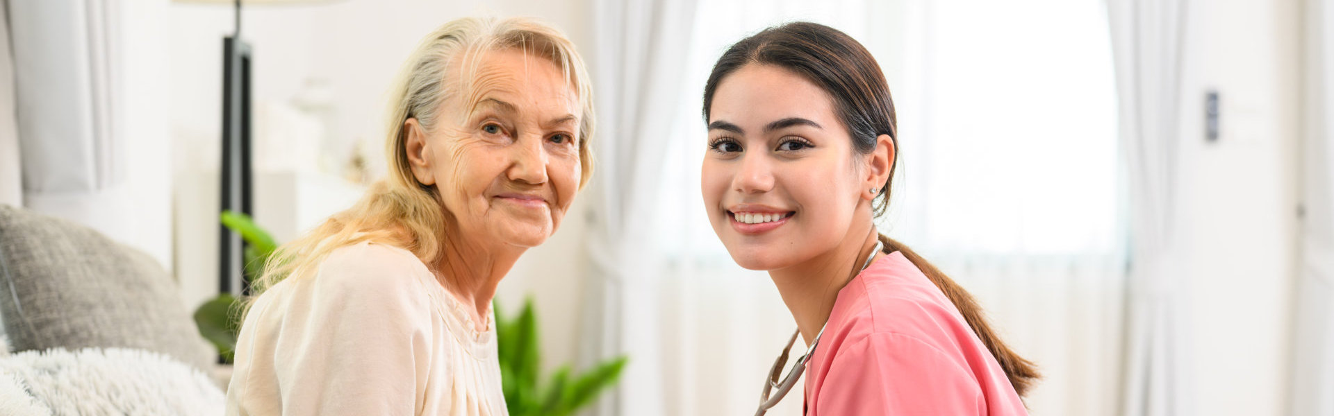 female caregiver and elderly woman smiling