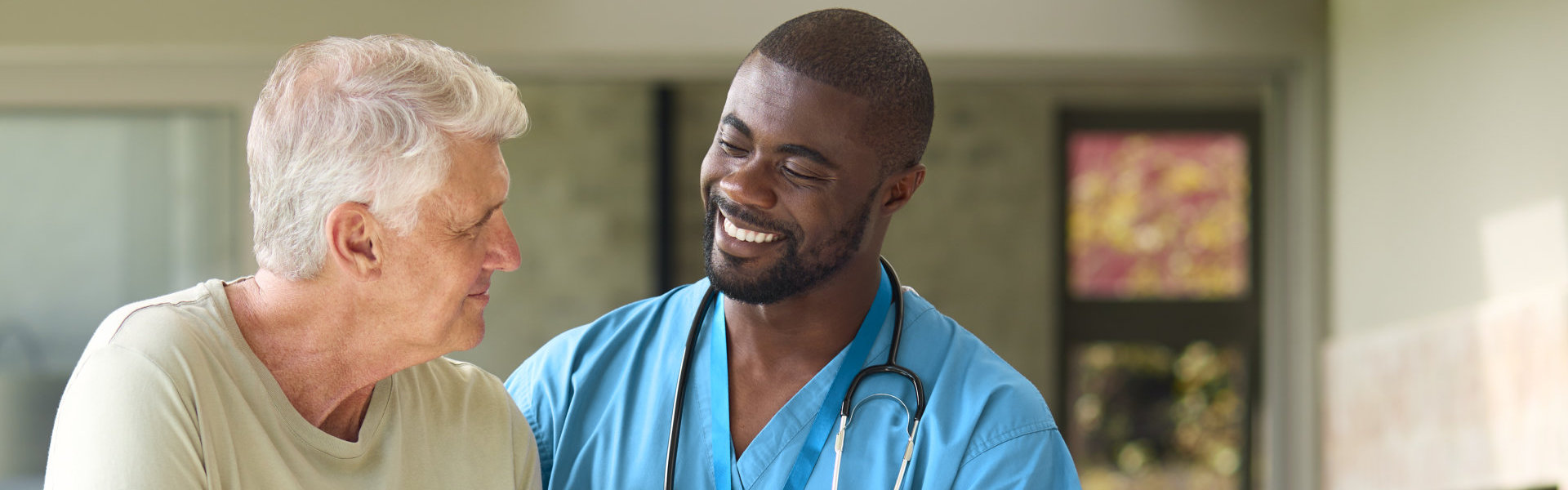 male caregiver and elderly man smiling