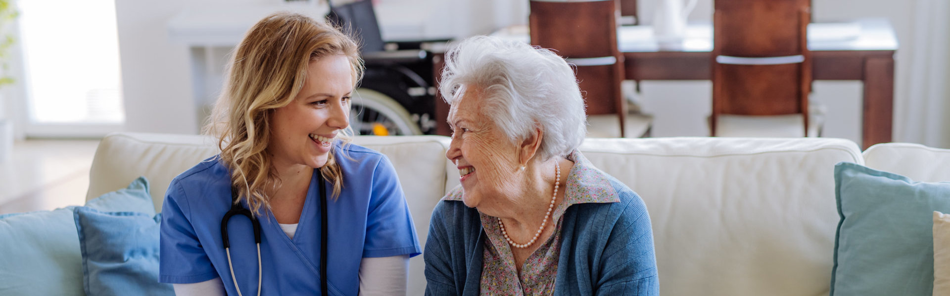 female caregiver and elderly woman smiling