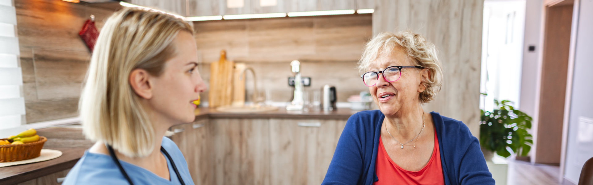 female caregiver and elderly woman talking