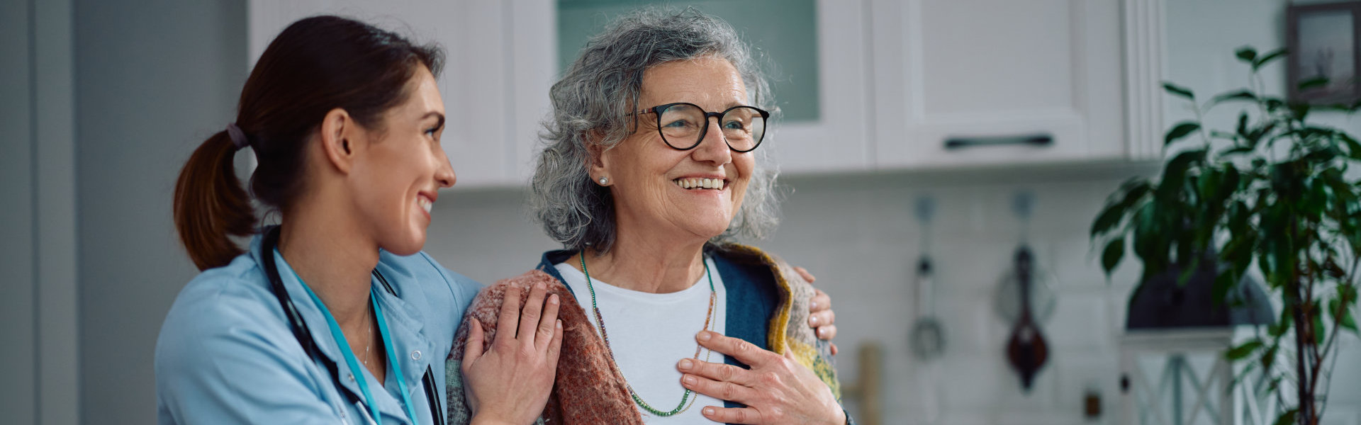 female caregiver and elderly woman smiling